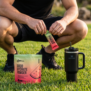 Man pouring a GoodHydrate Watermelon sachet into a bottle outdoors, pack beside him